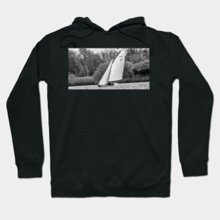 A lone brown boat sailing around Wroxham Broad, Norfolk Hoodie